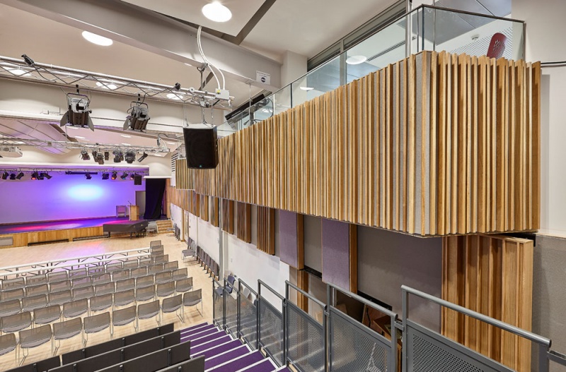 A selection of our acoustic wood products were specified for the new performing arts centre at Putney High School and installed by our team.
For the side walls, we installed our Soundtrac stretch system with Cara fabric, and fitted bespoke QRD panels finished in Oak on brackets to make them reversible, allowing the user to vary the acoustics of the room.
The upper level balconies are clad in our new modular timber panels, 25mm fabric covered panels with real oak strips mounted on the face, factory finished for quick site installation.
Photos: Adam Coupe Photography 6.jpg